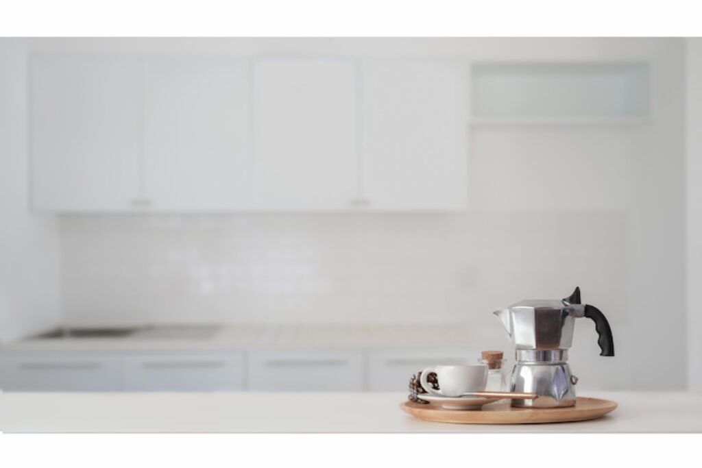 Cafeteira no lado direito em um fundo cinza.