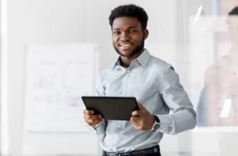Homem executivo sorrindo com um tablet na mão.