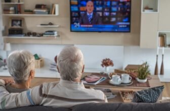 Casal de idosos assistindo TV.