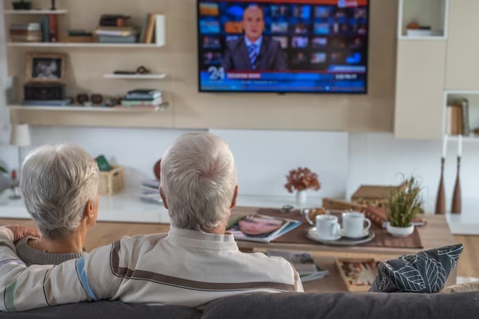 Casal de idosos assistindo TV.