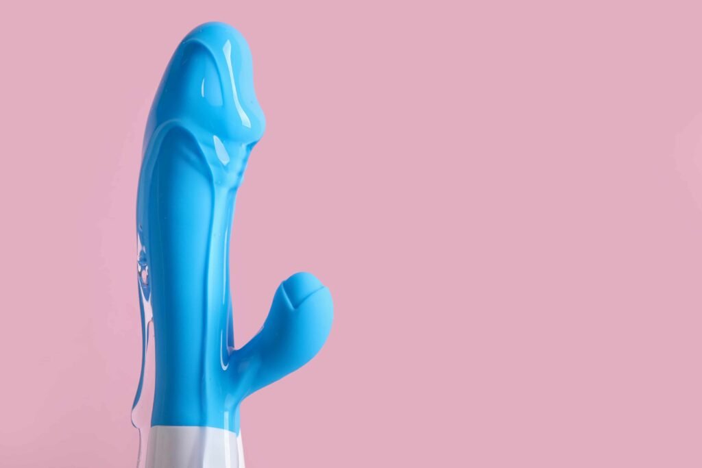 Vibrador azul em um fundo rosa.