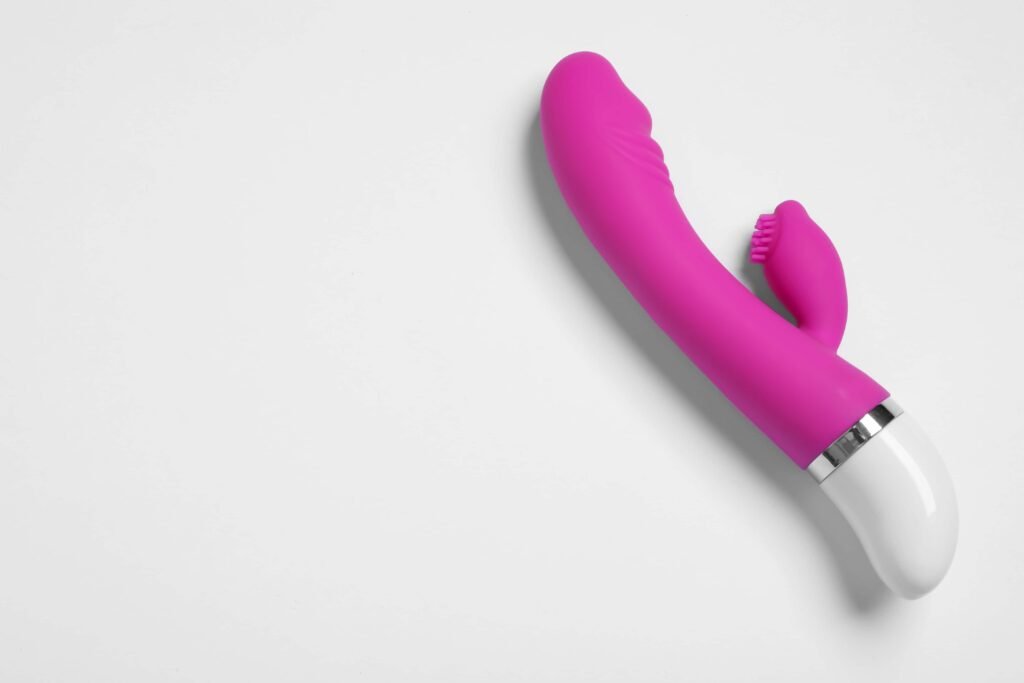 Vibrador rosa no fundo cinza.