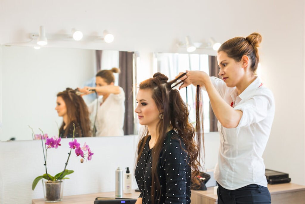 Pessoa fazendo babyliss em uma mulher.