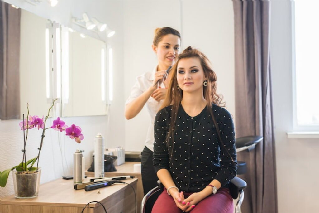 Cabeleireira aplicando babyliss na cliente.