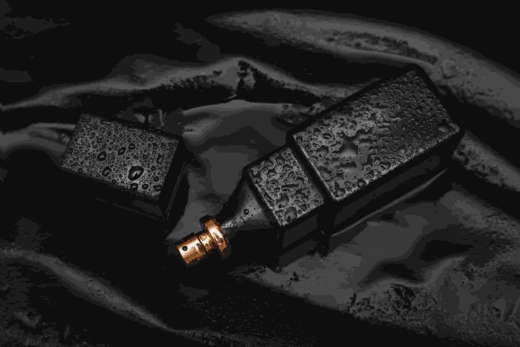 Perfume de frasco preto molhado.