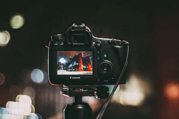 Uma câmera Canon em um tripé em um ambiente externo e de noite