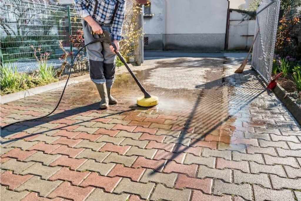 Chão de paralelepipedo sendo higienizado com uma lavadora.