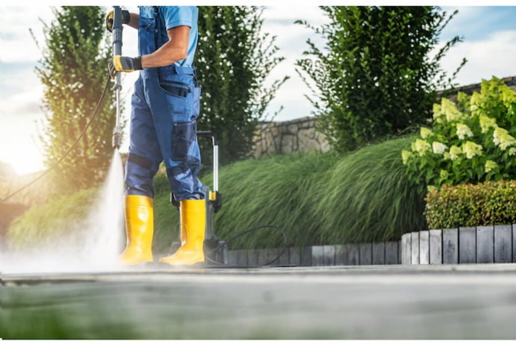 Homem lavando chão de um jardim com a melhor lavadora alta pressão.