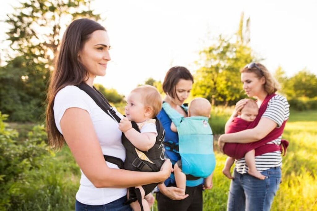 3 mães segurando 3 bebês no melhor canguru para bebês