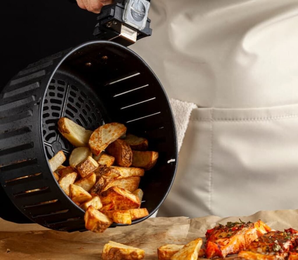 Uma grelha de air fryer removível com batatas fritas.