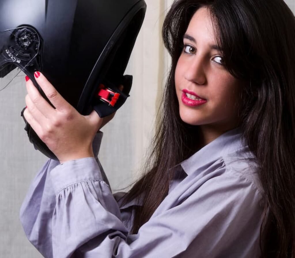 Uma mulher colocando um melhor capacete de moto feminino na cabeça.