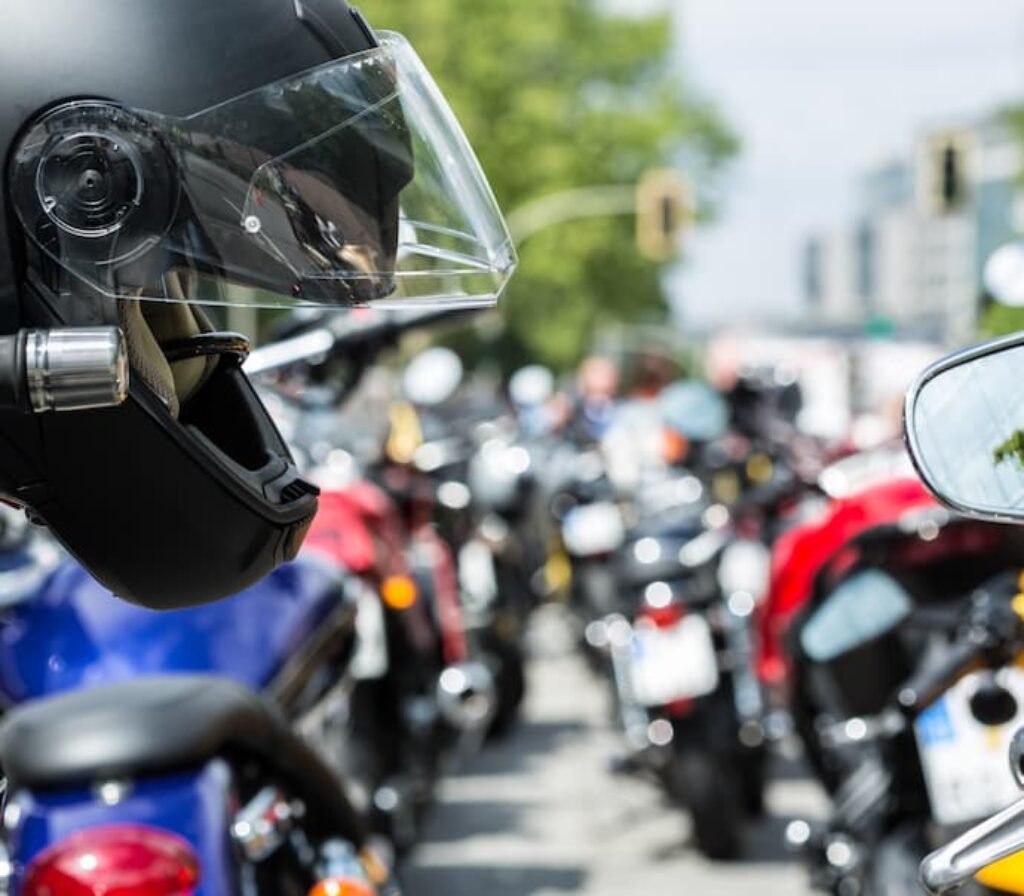 Um capacete de moto pendurado no guidão de uma motocicleta.