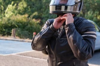 Um homem com jaqueta de couro tirando o melhor capacete de moto da cabeça.