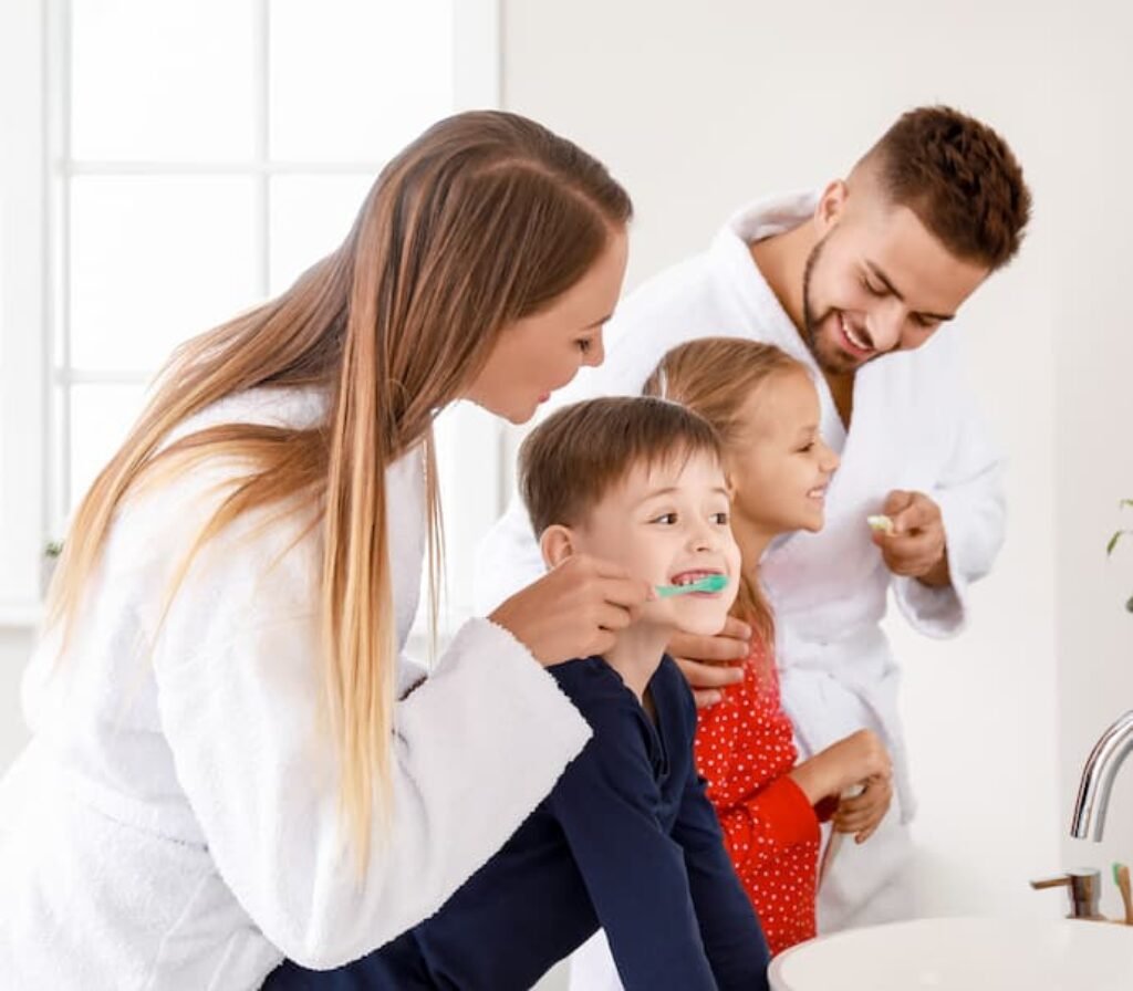 Uma família escovando os dentes em um banheiro.