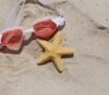 Um óculos de natação em cima da areia e ao lado de uma estrela