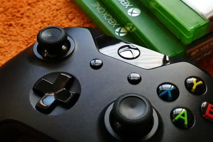 controle de xbox one ao lado de jogos