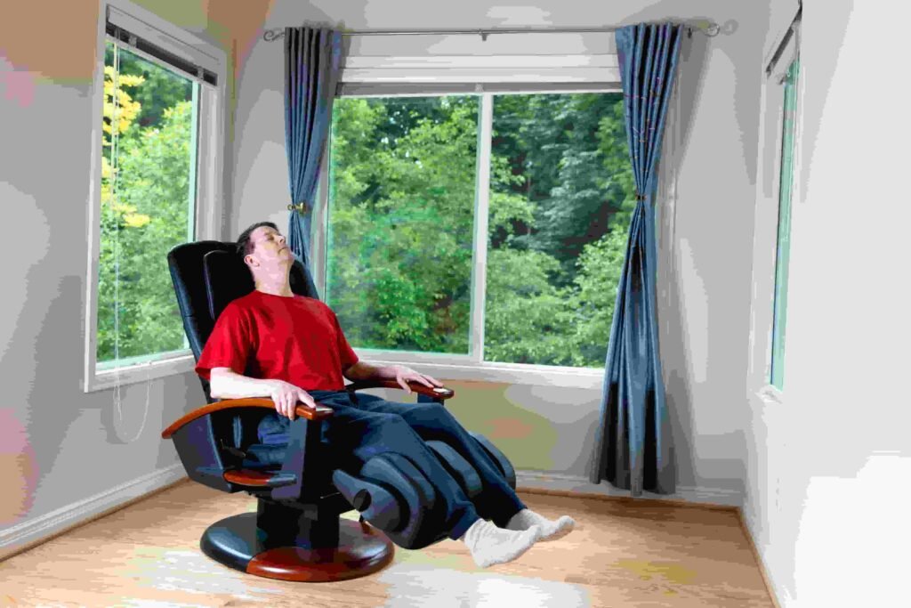 Homem relaxando em uma cadeira de massagem.