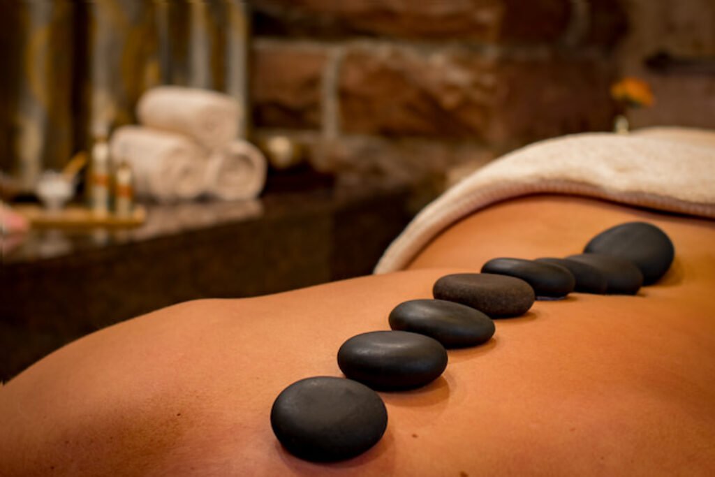 Mulher sendo massageada com pedras.