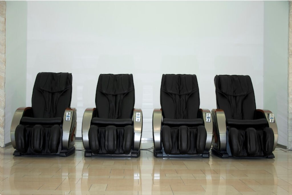 Quatro cadeiras de massagem, uma ao lado da outra.
