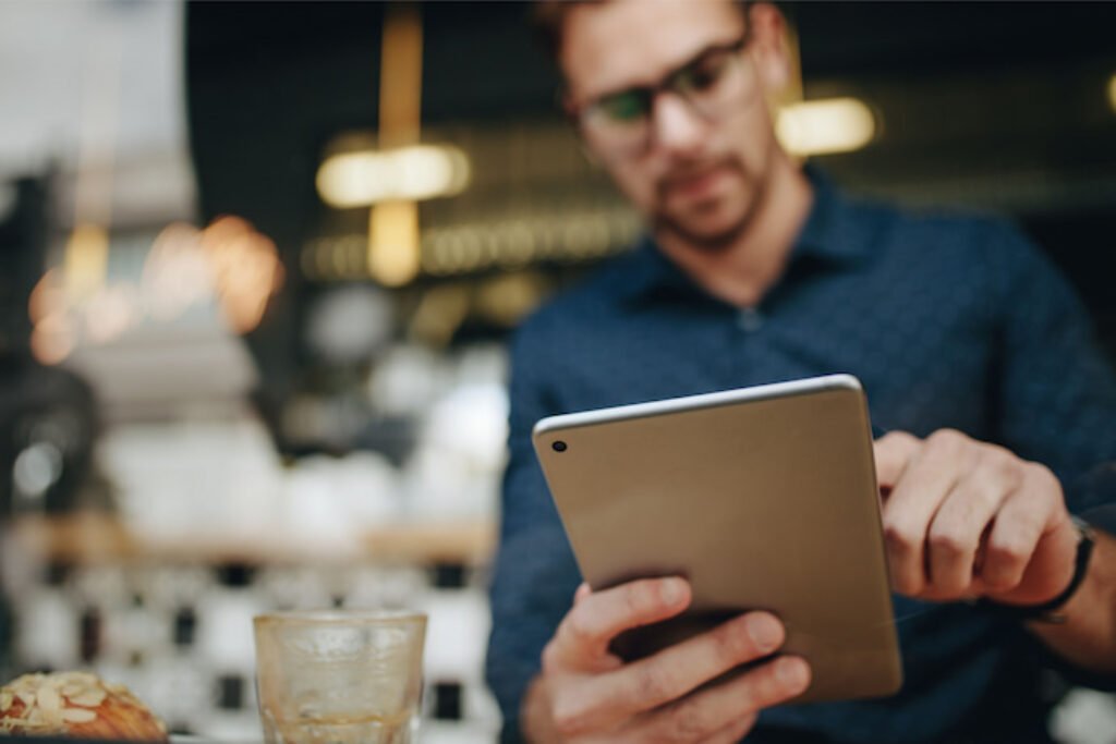 Homem com blusa azul usando uma mesa digitalizadora.