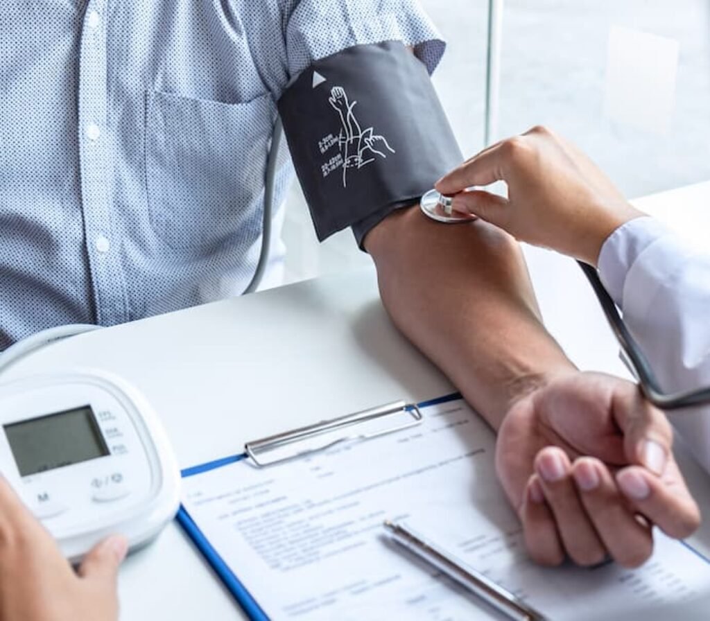 Um médico usa um aparelho de pressão digital para o braço em um paciente.