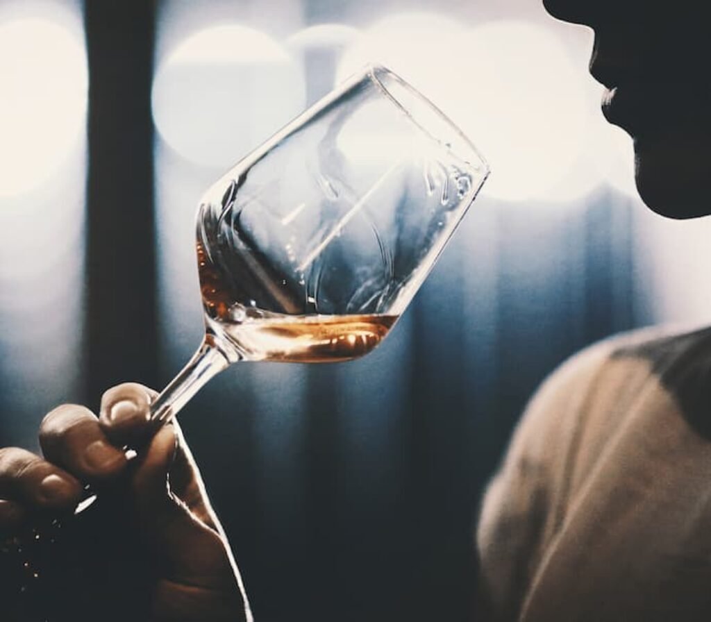 Uma mulher experimentando uma taça de vinho.