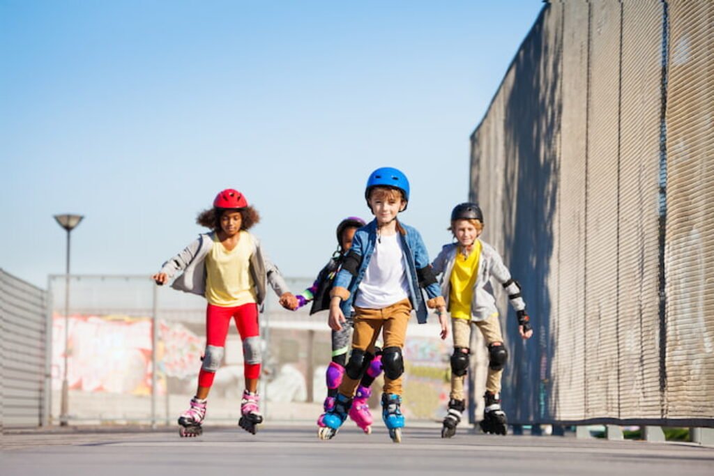 Grupo de quatro crianças andando de patins.