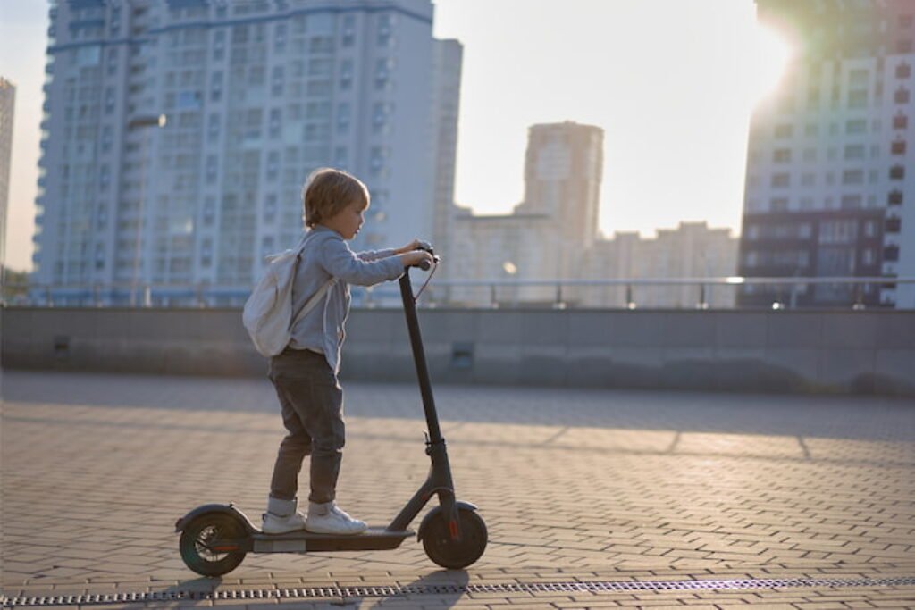 Criança andando de patinete na cidade. 