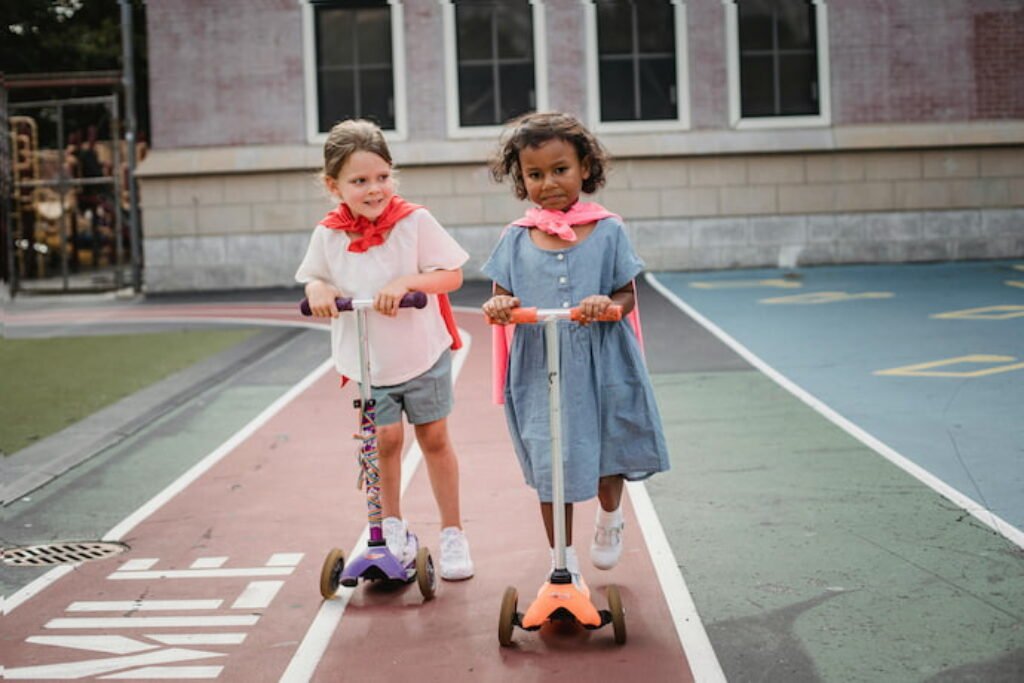 Duas meninas de patinete.