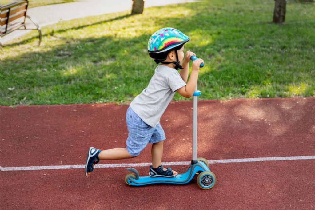 Menino andando de patinete. 