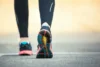 Pessoa caminhando com um tênis de corrida.