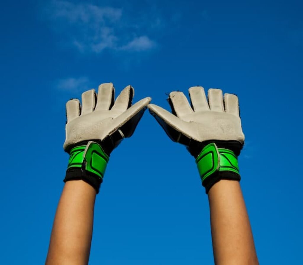 Uma pessoa usa um par de melhor luva de goleiro de látex natural.