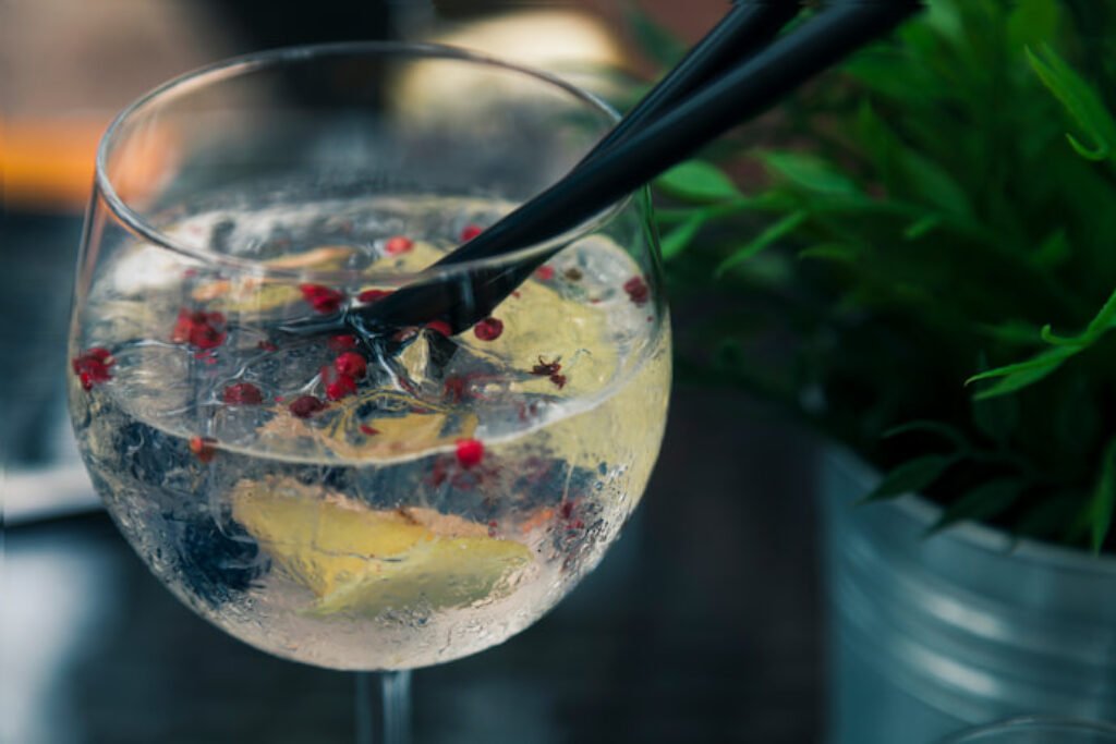 Taça de gin com dois canudos.