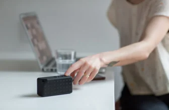 Pessoa ligando uma caixa de som bluetooth.