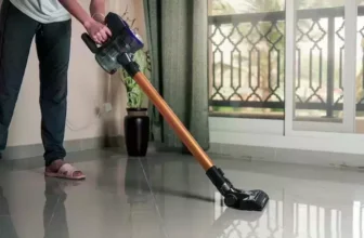 Pessoa limpando o chão com uma extratora de sujeira.