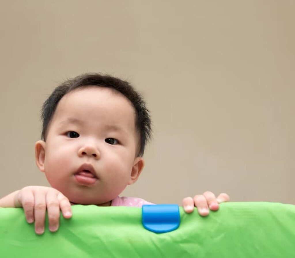 Um bebê dentro de um berço infantil.
