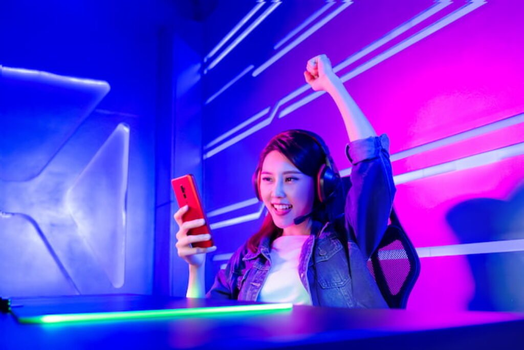 Menina comemorando uma partida no celular.