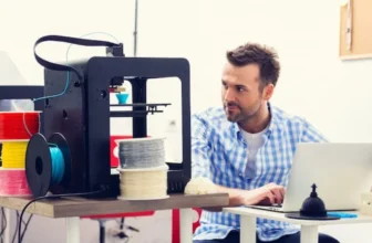 Um homem mexendo em um software de corte na frente de uma melhor impressora 3D.