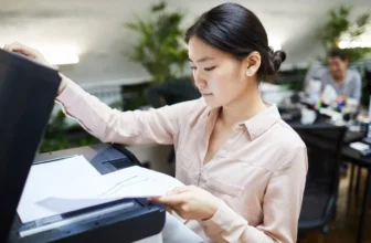 Uma mulher em um escritório usando uma melhor impressora custo-benefício.