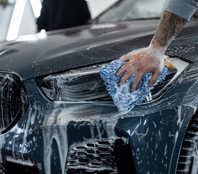 O melhor shampoo para carro sendo utilizado para lavar a frente de um carro.