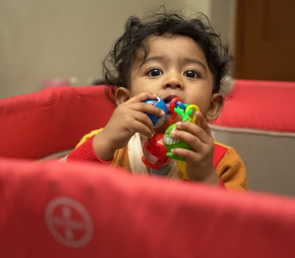 Uma criança brincando dentro de um dos melhores berços portáteis.