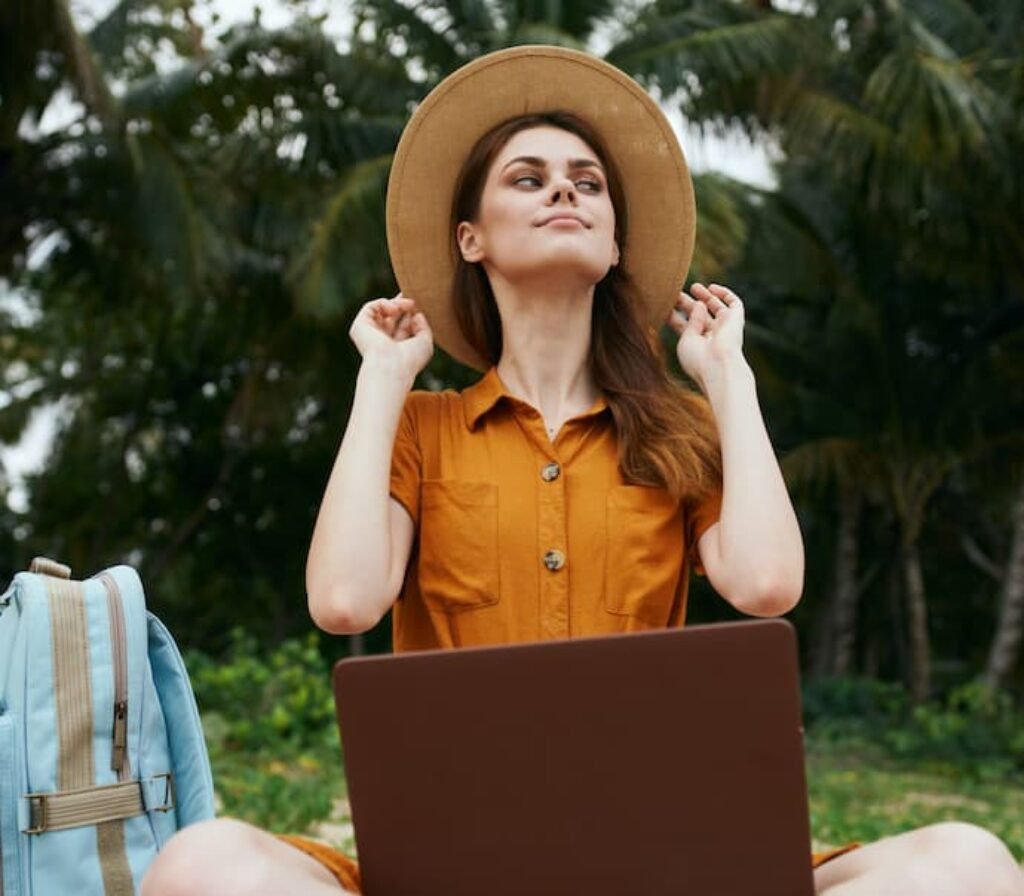 Uma mulher de chapéu, um note e uma mochila para notebook