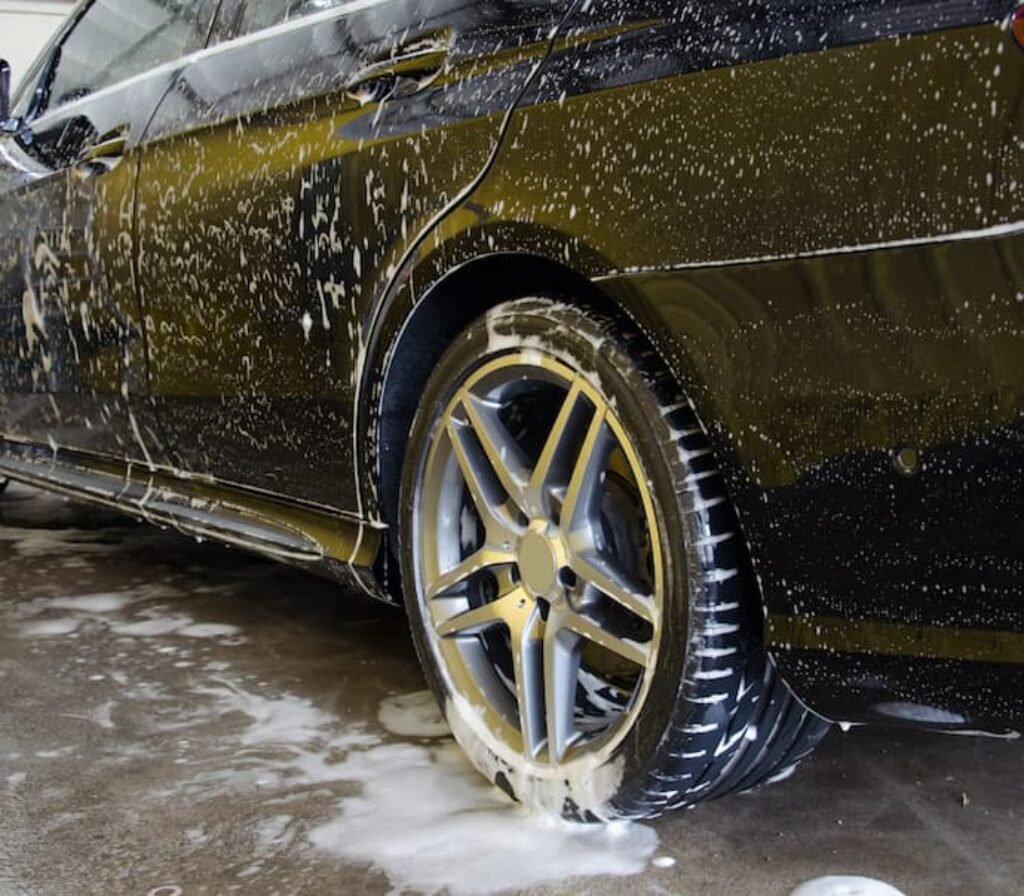 Carro molhado e com espuma de shampoo automotivo.