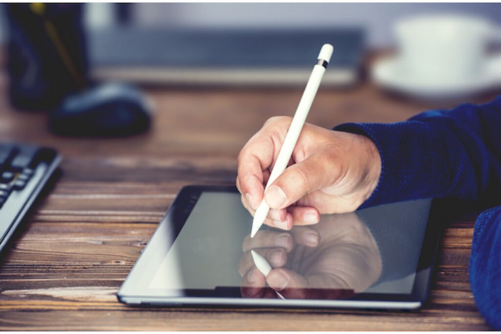 Uma pessoa desenhando em um tablet.