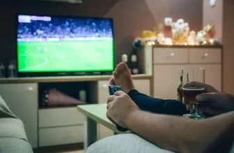 Rapaz assistindo jogo de futebol na melhor TV 4K.