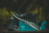 Tênis Adidas com uma caixa ciano atrás.
