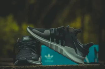 Tênis Adidas com uma caixa ciano atrás.