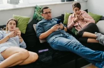 Três pessoas em um sofá mexendo no melhor celular até 2000