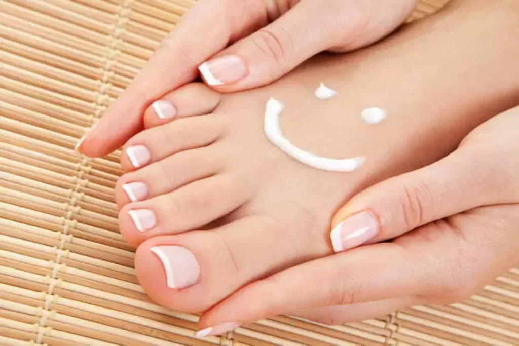 Um creme desenhado como um sorriso no pé de uma pessoa.