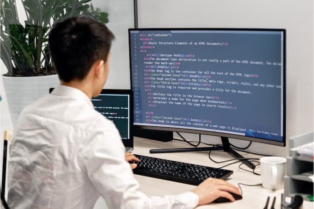 Um programador programando em em um melhor monitor 4k.